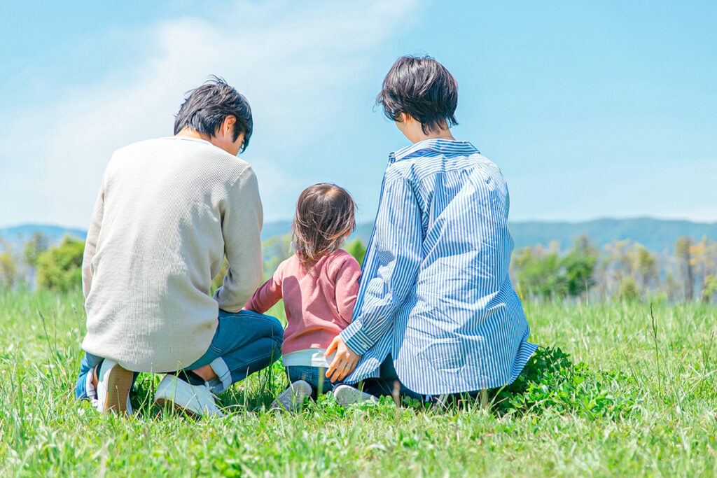 公園に座る家族の後ろ姿